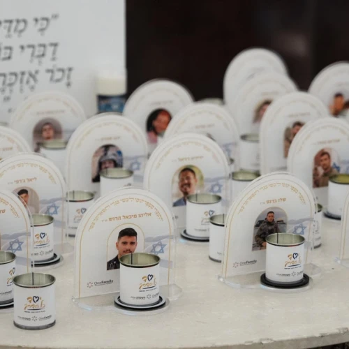 Memorial candles in front of images of the fallen at the OneFamily Passover weekend. Photo by Meir Pavlovsky.