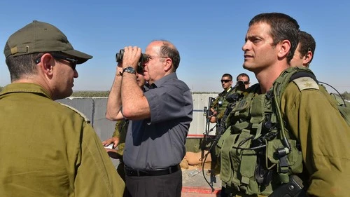 Click photo to download. Caption: Israeli Defense Minister Moshe Ya'alon (with binoculars) pictured during a visit to the Israel Defense Forces (IDF) Southern Command's Gaza Division on Tuesday. The IDF launched Operation Protective Edge in Gaza in response to escalated rocket fire by Hamas. Credit: Ariel Hermoni/Ministry of Defense/Flash90.