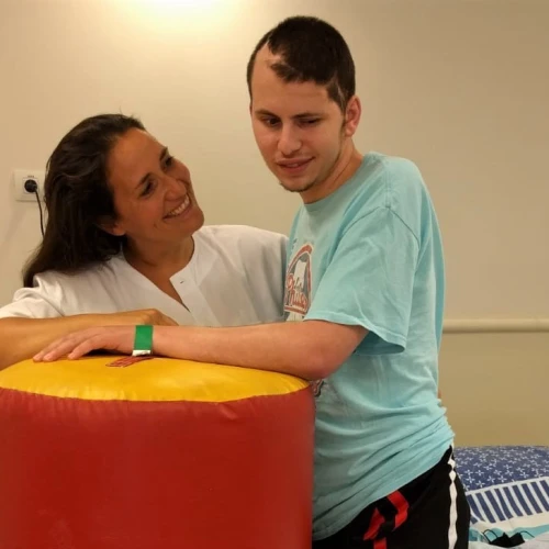 Dr. Adi Gidali, a New York-trained physical therapy supervisor at the Outpatient Brain Injury Unit at Sheba Medical Center, with 24-year-old recovering patient Netanel Felber. Credit: Sheba Medical Center.