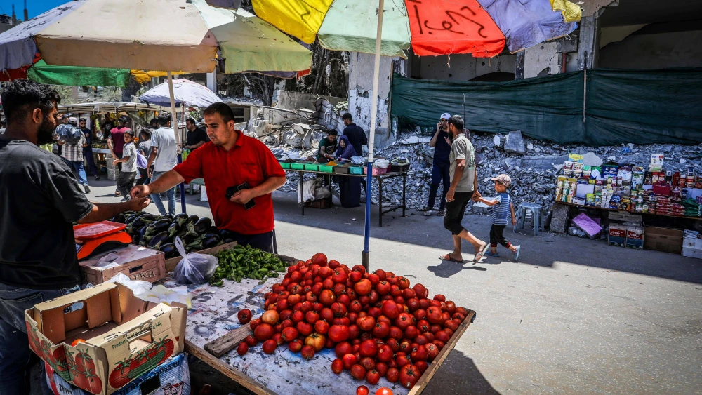 Palestinians shopping at a market next to destroyed buildings in Deir al-Balah, in the central Gaza Strip, May 31, 2024. Photo by Abed Rahim Khatib/Flash90.