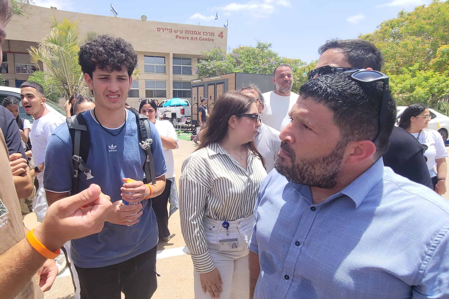 Almog Cohen, right, speaks with protesters demonstrating against Yair Golan at a conference in Be'er Sheva, Israel on may 27, 025. Photo by Canaan Lidor.