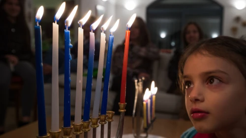 A child observes the candles on a fully lit Hanukkah menorah, Dec. 12, 2015. Photo by Nati Shohat/Flash90.