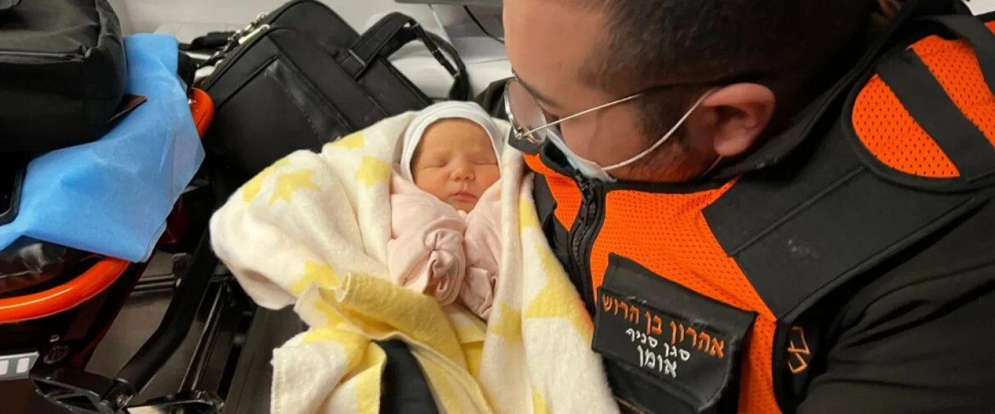 Aharon ben-Harush, deputy commander of United Hatzalah’s relief mission to the Ukrainian-Moldovan border, in an ambulance with one of the Israeli newborns he helped rescue from war-torn Kyiv. Photo courtesy of United Hatzalah.