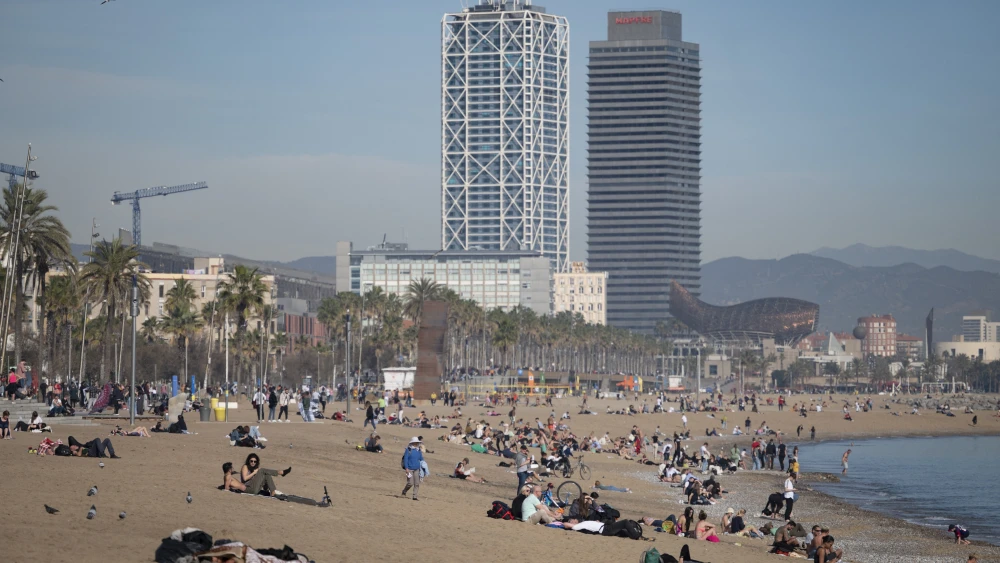 People sunbathe on San Sebastian beach in Barcelona, Spain, on Jan. 26, 2024. Photo by JOSEP LAGO/AFP via Getty Images.