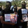 Members of the Al-Quds Brigades, the military wing of the Palestinian Islamic Jihad, hold pictures of French President Emmanuel Macron during a protest march in the southern Gaza Strip against the reprinting of a cartoon of the Prophet Muhammad in France, on Oct. 26, 2020. Photo by Abed Rahim Khatib/Flash90.