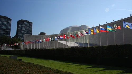 The row of flags of member countries of the United Nations in front of the U.N. General Assembly building in New York. Credit: Wikimedia Commons.