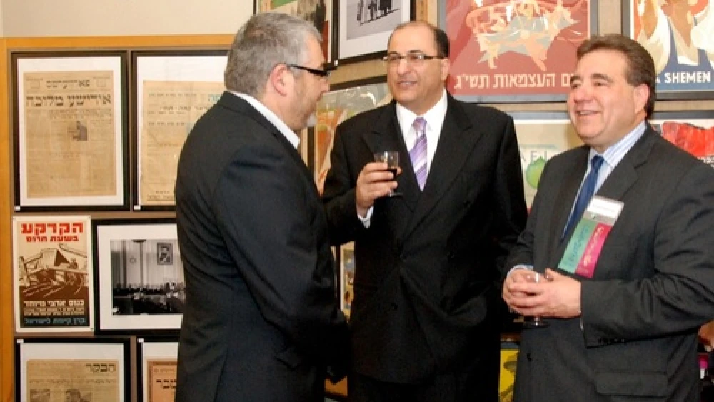 Aharon Farkash (left), director of the Farkash Gallery in Israel, joins Israel's Consul General in New York Ido Aharoni and Jewish National Fund CEO Russel F. Robinson March 28 at the opening of the "Made in Israel 2012" exhibit (which can be seen in the background). Credit: Maxine Dovere.