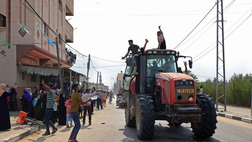 Palestinians drive an Israeli tractor that was seized after crossing the border fence with Israel from Khan Yunis in the southern Gaza Strip on Oct. 7, 2023. Photo by Said Khatib/AFP via Getty Images.