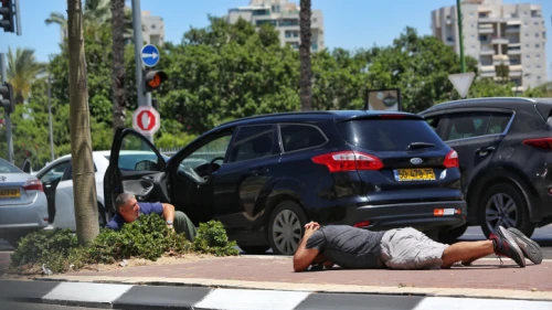 Israelis take cover in Ashkelon as a Red Alert siren warns of incoming rockets from the Gaza Strip, May 19, 2021. Photo by Edi Israel/Flash90.