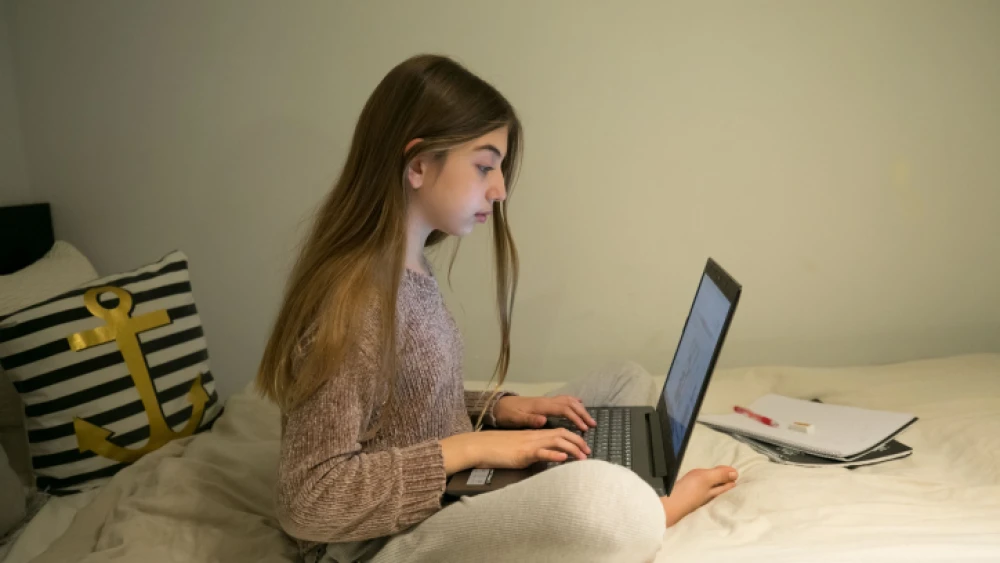 An Israeli teen attends an online class from her home in Moshav Haniel, on March 18, 2020. Photo by Chen Leopold/Flash90.